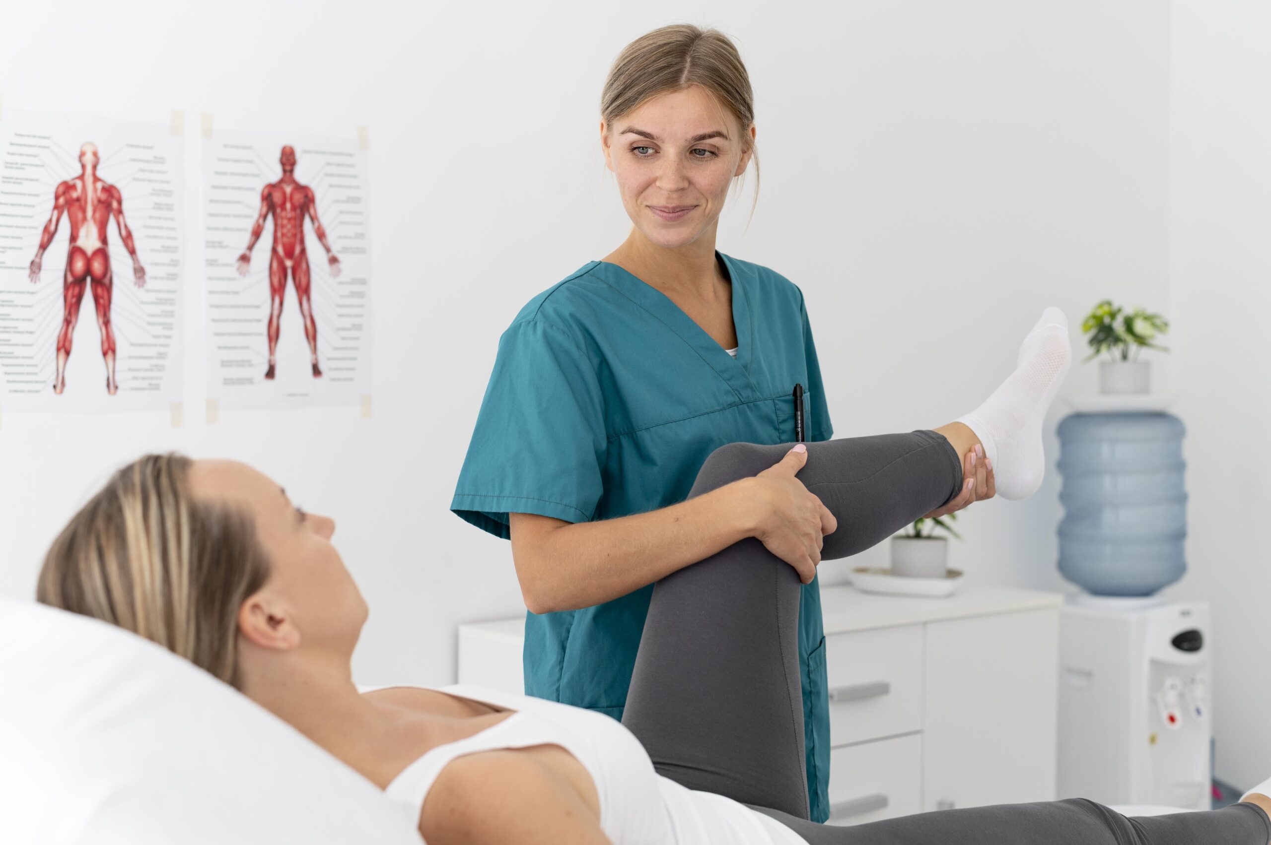 Physiotherapeutin prüft Beinbeweglichkeit Patientin.