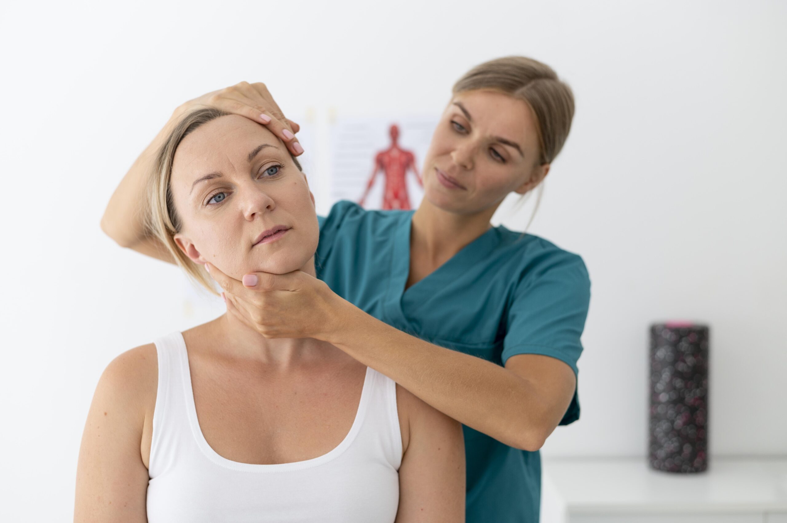 Physiotherapeutin behandelt Nacken einer Patientin.